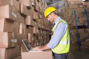 man on computer in warehouse